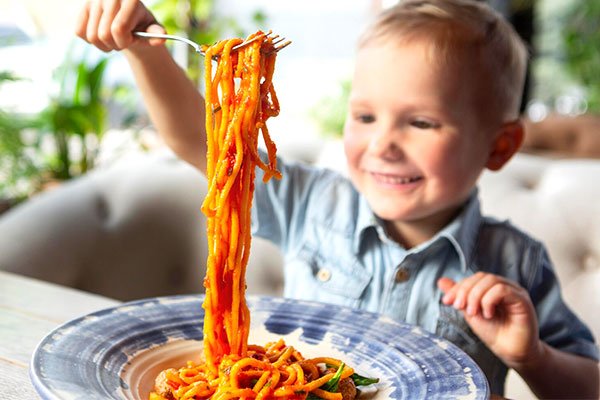 Menino manipulando comida sozinho, mostrando coordenação e habilidades motoras